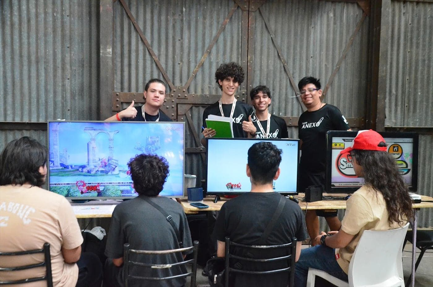El equipo de Team Anexo detrás de las pantallas de un torneo en un galpón