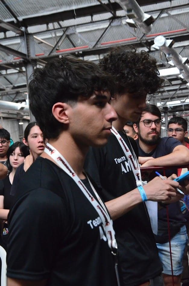 Jugadores con remeras de Team Anexo y credenciales mirando una partida